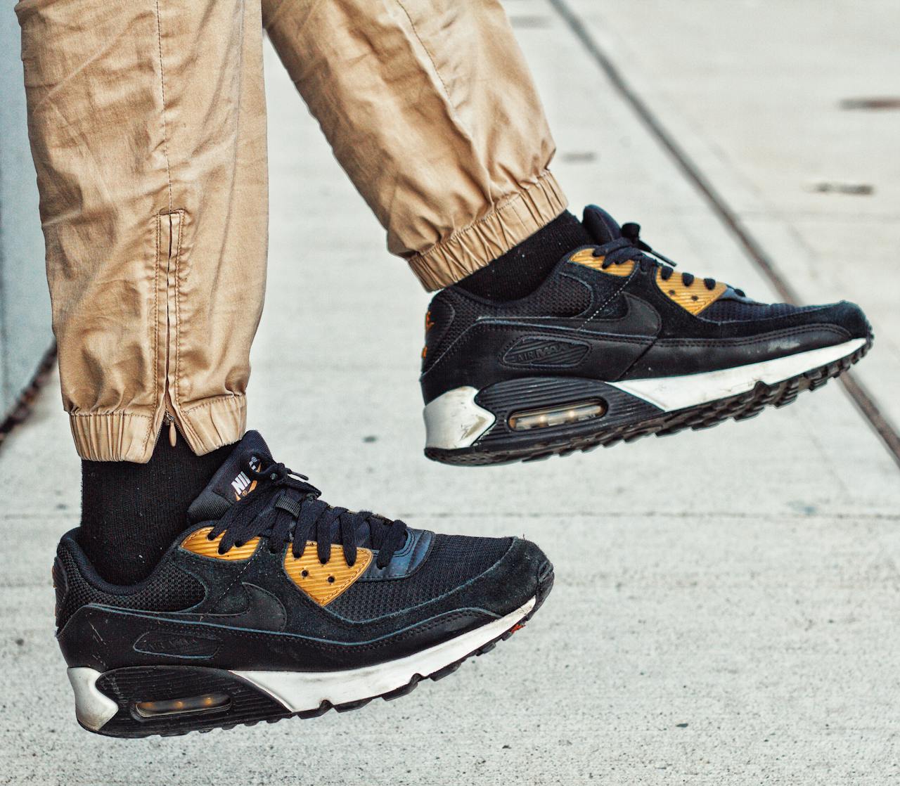 Services-02 Casual street style with black and gold sneakers in motion.