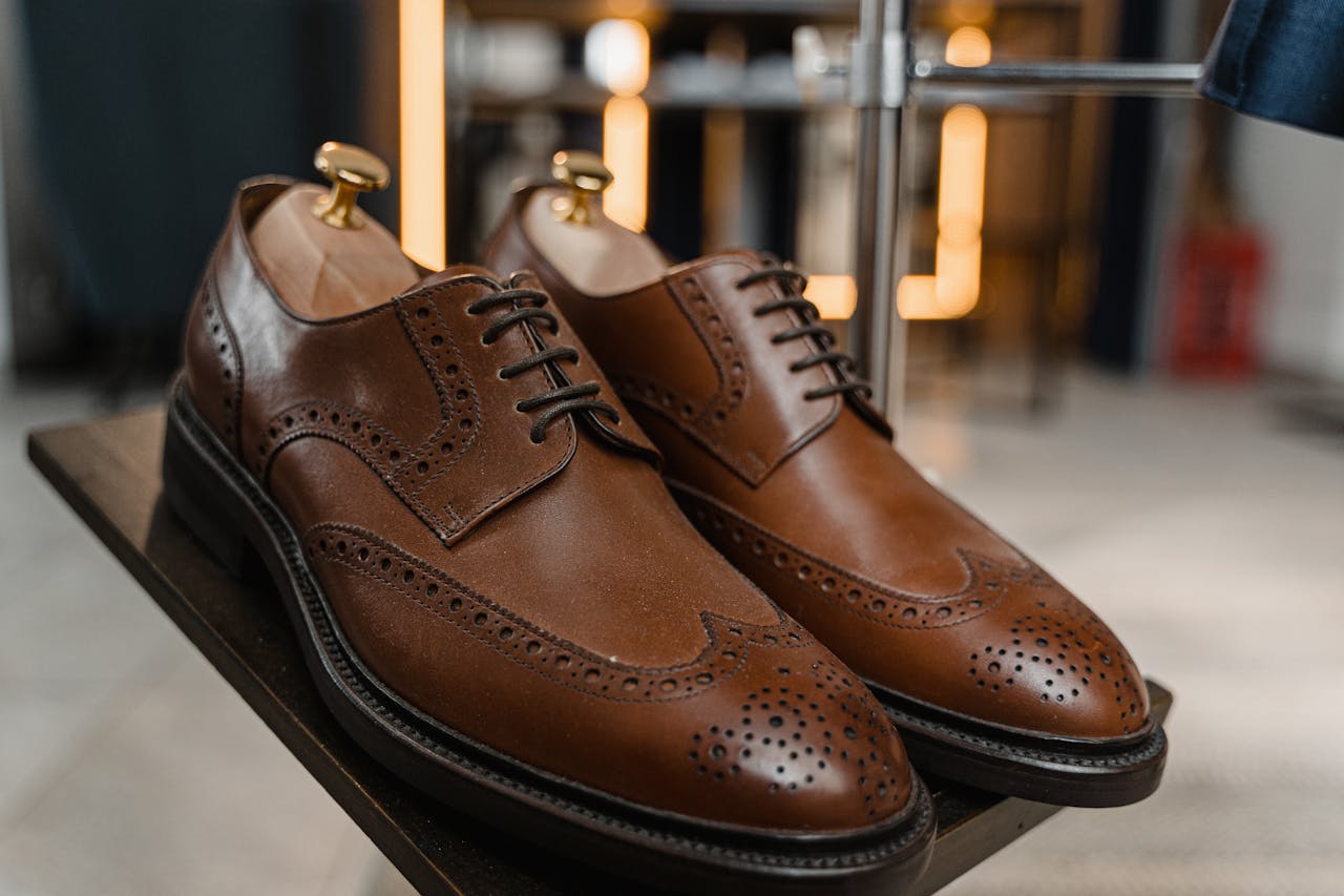 creative Classic brown leather brogue shoes with detailed perforations on a stylish display.
